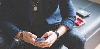 man using his iphone 6 on a sofa picjumbo com e1486412663126