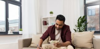 man with money and calculator filling papers