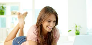 Tilt up of an attractive young woman working on her laptop at home