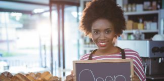 Woman holding sign signaling that the store is open