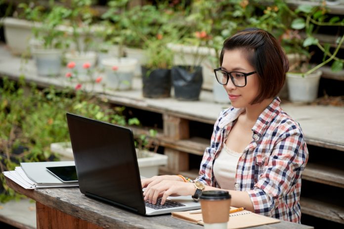 Woman working on computer outdoors