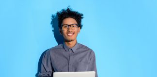 Happy man with laptop against a blue background