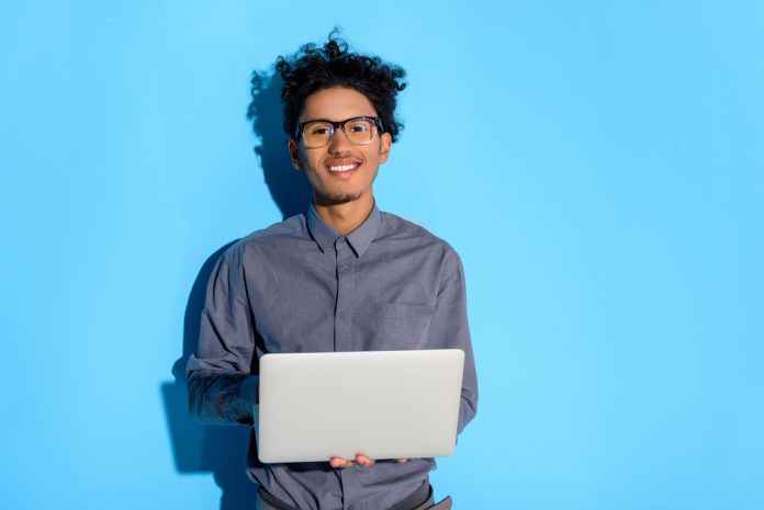 Happy man with laptop against a blue background