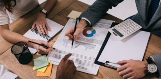 Business coworkers doing finance work while sitting at a table