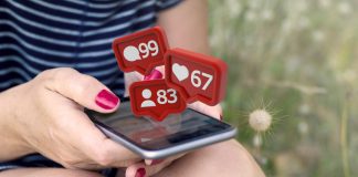 Sitting woman checking notifications on smartphone on the grass