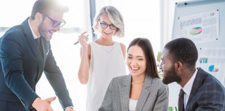 Businesspeople laughing while working on project in office