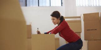 happy woman during move with boxes at new flat and packing carton