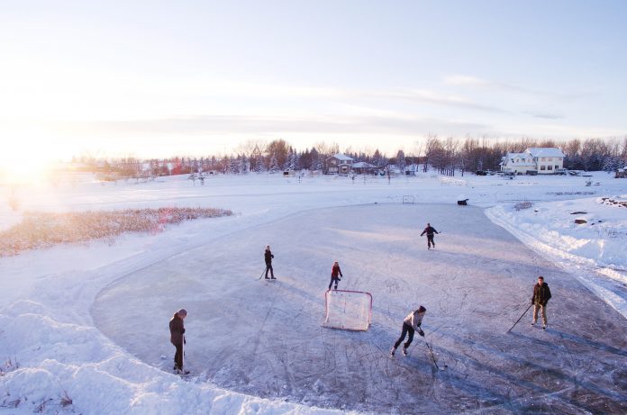 People playing ice hockey on frozen ground