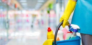 Person holding bucket of cleaning supplies