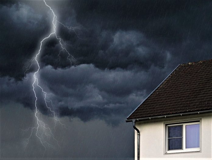 House with a rainy sky and lightning