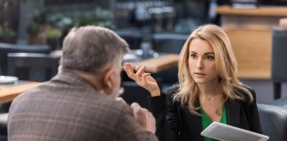 Businesswoman with tablet having business meeting with colleague in cafe