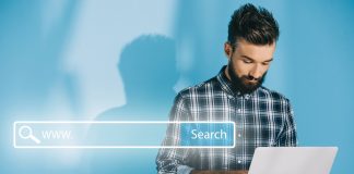 Bearded developer using laptop, on blue with website search bar