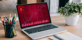 Laptop with red business graph standing at workspace