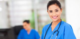 Attractive young female nurse holding tablet computer at workplace