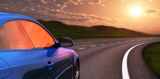 Blue car driving by autobahn in sunset with motion blur effect