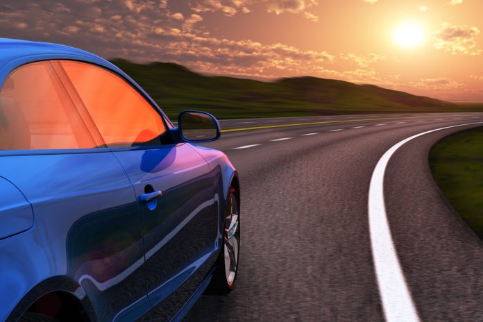 Blue car driving by autobahn in sunset with motion blur effect