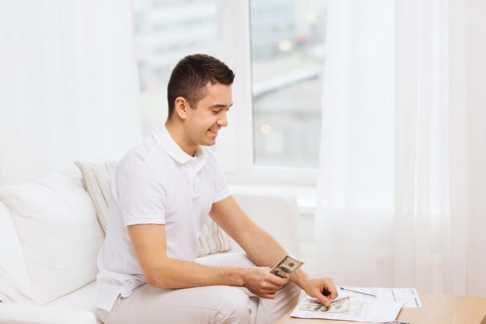 man with papers and calculator at home