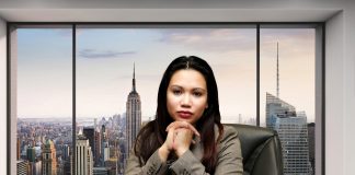 Woman sitting at disk with skyline in background