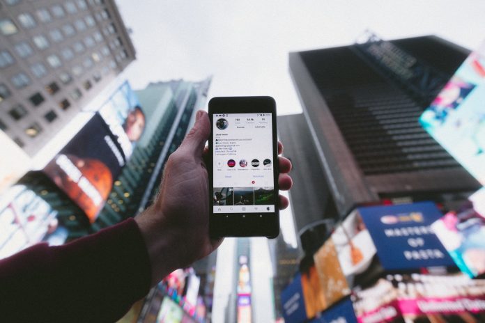 Instagram on mobile phone against Times Square background