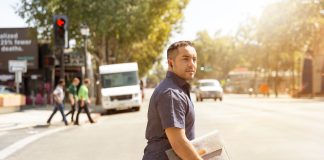 Young man walking across the street