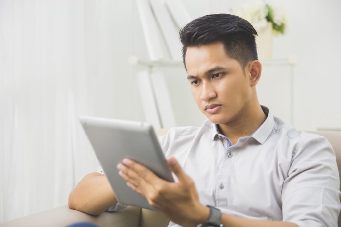 portrait of handsome man using tablet PC at home