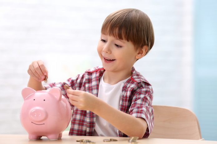 Boy with piggy bank on blurred background