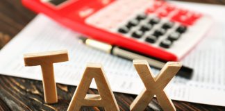 Word TAX and calculator on wooden table