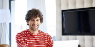 Shot of a handsome young man sitting in front of laptop and working online from home office