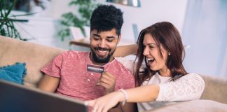 Young couple shopping online with credit card at home