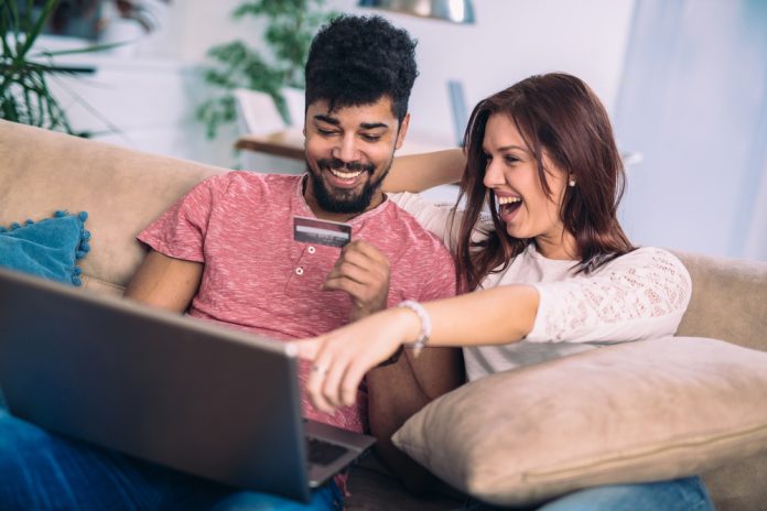 Young couple shopping online with credit card at home