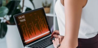 Cropped view of businesswoman using laptop with online trade graph