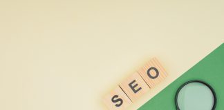 Top view of wooden cubes with seo lettering and magnifier glass