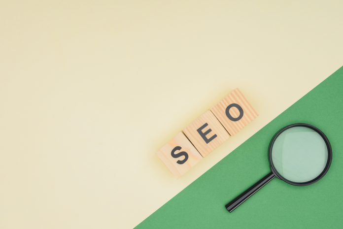 Top view of wooden cubes with seo lettering and magnifier glass