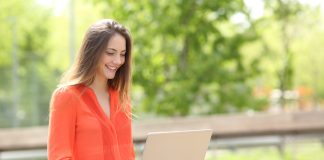 Entrepreneur working with a laptop sitting on a bench in a park