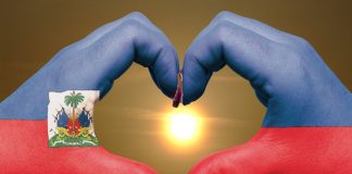 Heart and love gesture by hands colored in Haiti flag