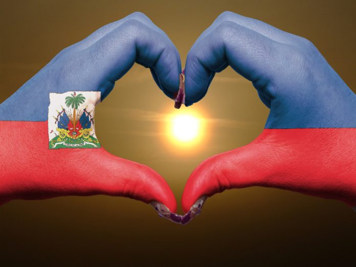 Heart and love gesture by hands colored in Haiti flag
