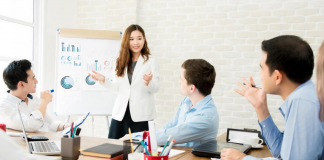 Woman giving presentation to business team