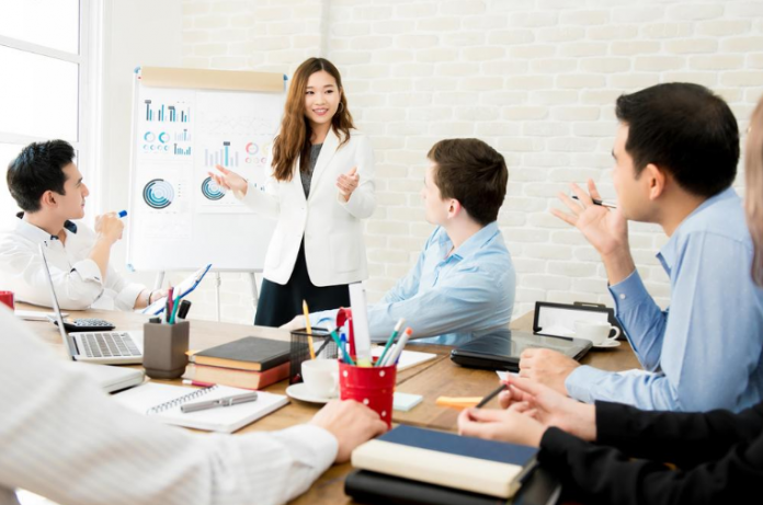 Woman giving presentation to business team