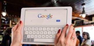 Woman holding tablet with Google homepage on screen