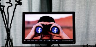 Facebook in binoculars on laptop