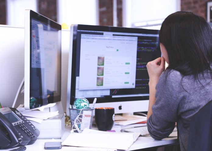 Businesswoman working at computer monitors