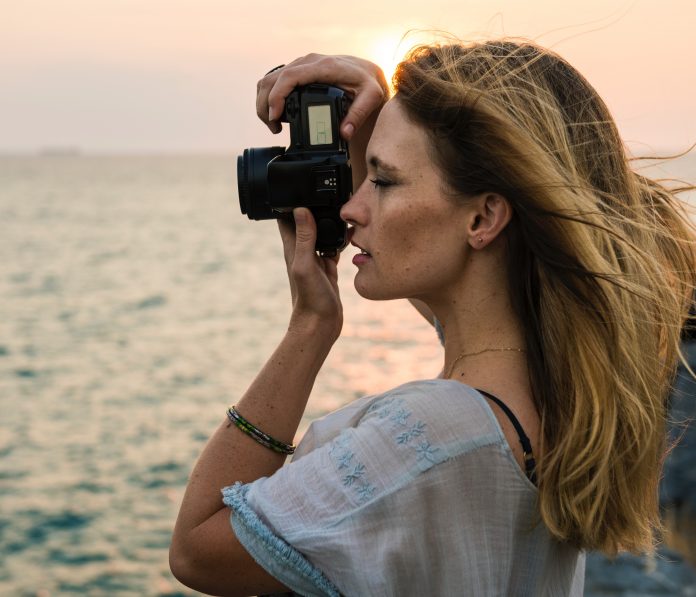 Woman taking picture of ocean