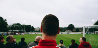 Man in red shirt looking at field