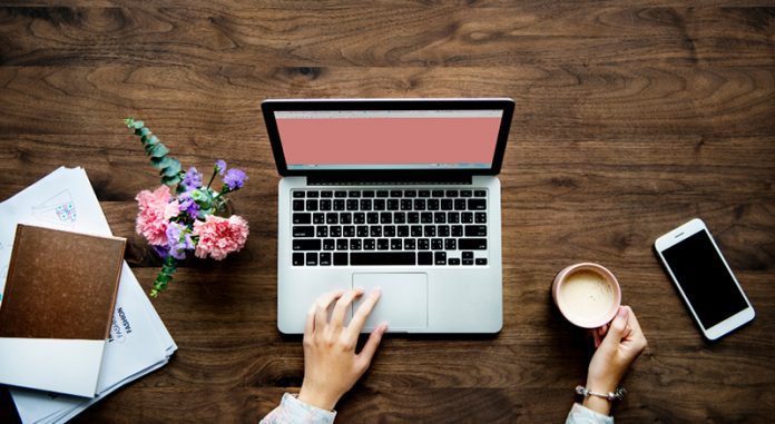 Laptop and office items on wooden desk