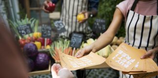 Person Handing Promotional Brochure to Customer