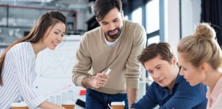 Group of young businesspeople discussing new business plan in small office meeting