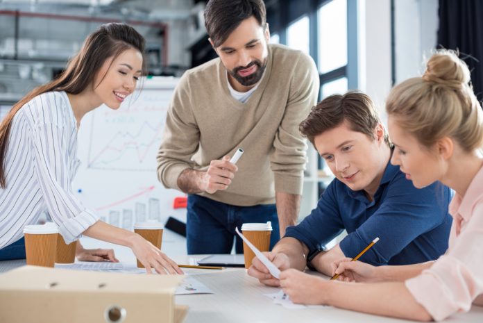 Group of young businesspeople discussing new business plan in small office meeting