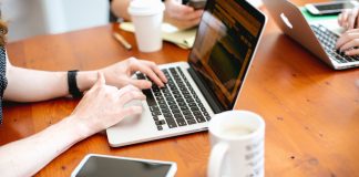 Business team working on laptops in meeting