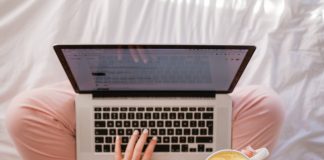 Woman working on her laptop and holding a coffee