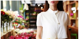 Woman in flower shop holding bouquet of flowers